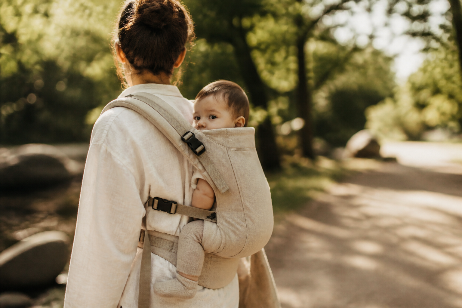 Parent wearing baby in a structured carrier outdoors